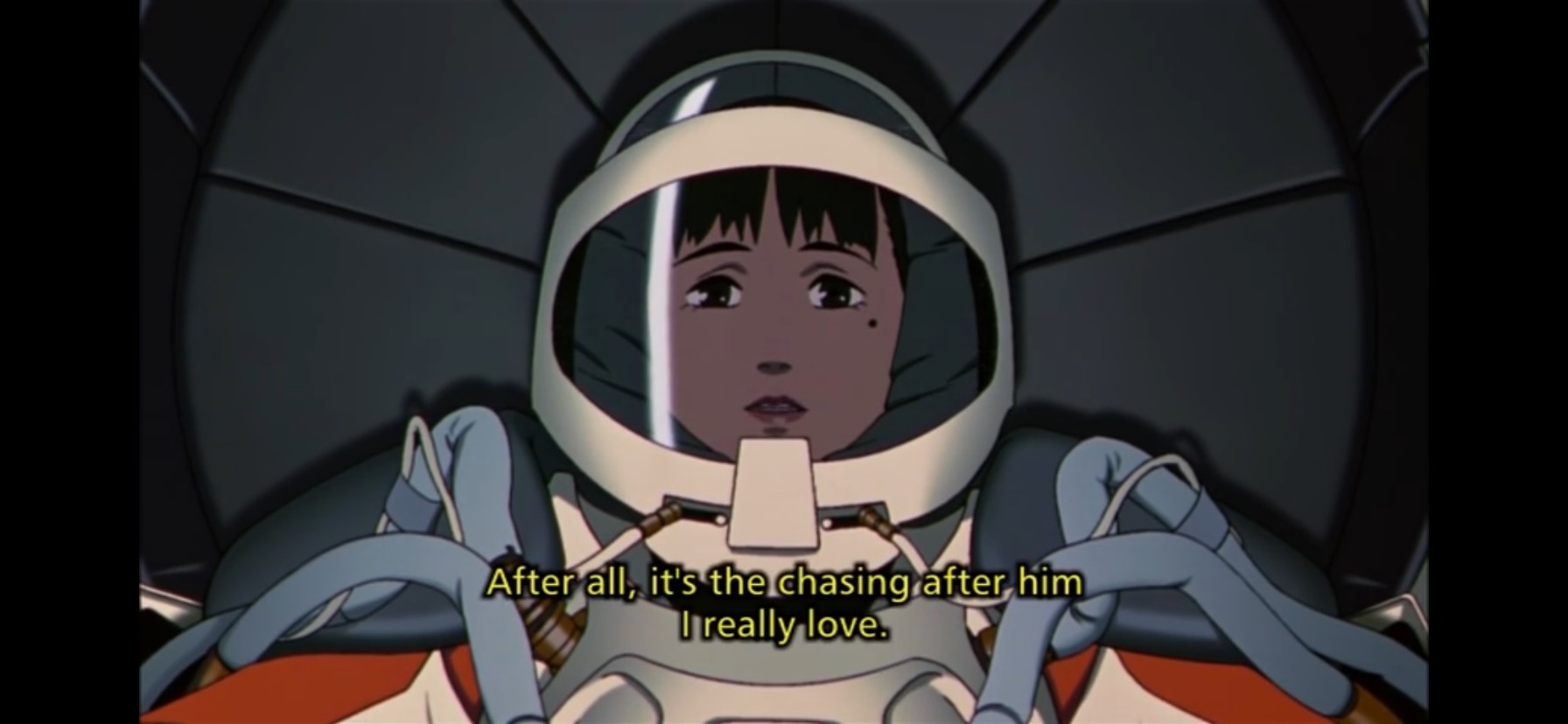 Chiyoko in her iconic space suit from her final film in a space ship, preparing to take off with no plans to return to earth. She is saying, 'After all, it's the chasing after him that I really love'
